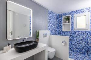 a blue and white bathroom with a black sink at Villa Aless in Skopelos Town +92 photos