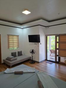 a living room with a couch and a flat screen tv at Buenacosa Resort in Panglao Island