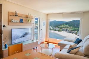 a living room with a tv and a large window at El BALCON DE BAKIO in Bakio
