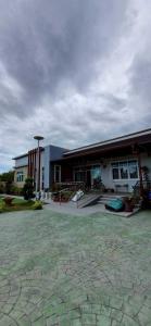 a large building with a patio in front of it at Mae Klong Garden House แม่กลอง การ์เด้น เฮ้าส์ in Samut Songkhram