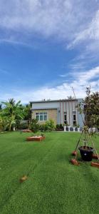 a large yard with a house and a green lawn at Mae Klong Garden House แม่กลอง การ์เด้น เฮ้าส์ in Samut Songkhram