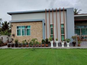a house with a lawn in front of it at Mae Klong Garden House แม่กลอง การ์เด้น เฮ้าส์ in Samut Songkhram