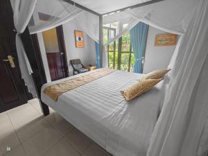 a bedroom with a canopy bed and a window at Villa Seaview- tranquil 3BR, beachfront, private pool in Bukti +39 photos