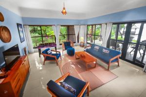 a living room with blue couches and a tv at Villa Seaview- tranquil 3BR, beachfront, private pool in Bukti