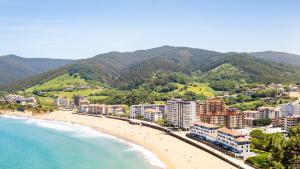 a view of a beach with buildings and the ocean at El BALCON DE BAKIO in Bakio