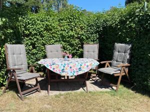 a table with two chairs and a table with a floral table cloth at Ferienhaus Präkel in Kloster