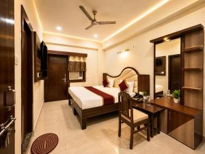 a hotel room with a bed and a desk and a bedroom at Hotel Pragati Palace in Mathura +32 photos