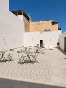 a group of tables and chairs on a patio at Liolà Rooms in Terrasini