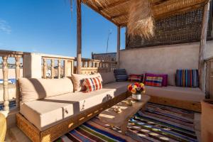 a porch with a couch and a table at Marrakech Medina - Private Riad 4 rooms Rooftop and pools in Marrakesh