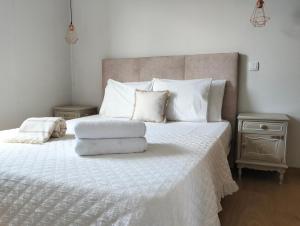 a bedroom with a large bed with white sheets and pillows at Casa do Largo do Cruzeiro in Vouzela +56 photos