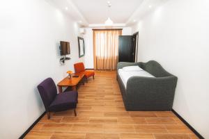 a living room with a couch and two chairs and a table at Marcos Hotel in Nizhnyaya Alekseyevka