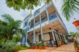 a blue and white house with palm trees at Arjun Homestay in Hampi