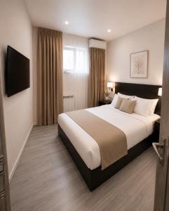 a hotel room with a bed and a television at White Hotel in Yerevan