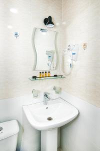 a white bathroom with a sink and a mirror at Marcos Hotel in Nizhnyaya Alekseyevka +88 photos