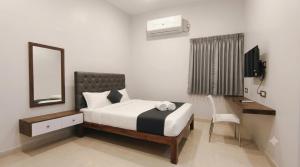 a bedroom with a bed and a mirror and a desk at L2 Retreat in Kottakupam