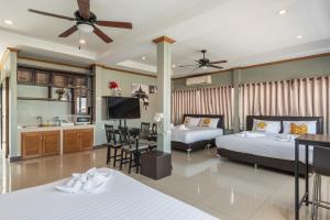 a bedroom with two beds and a kitchen with a dining room at BKK39 Airport Hotel in Lat Krabang