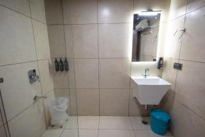 a bathroom with a shower and a sink and a toilet at The Arks Baagh Villas in Rāmnagar