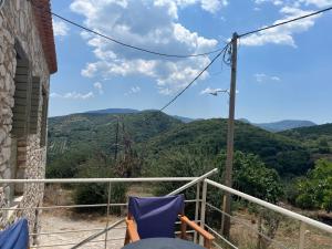 a balcony with chairs and a view of mountains at Polylimnio landscape in Groustésion