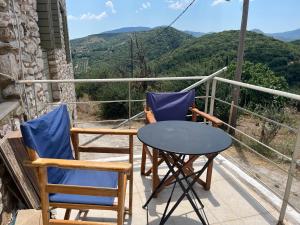 a balcony with two chairs and a table with a view at Polylimnio landscape in Groustésion