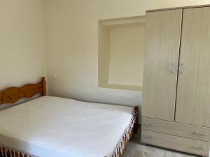 a bedroom with a bed and a wooden cabinet at Polylimnio landscape in Groustésion