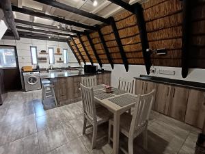 a kitchen with a table and chairs in a room at Cosy Cottage in Buffelspoort