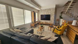 a living room with a couch and a tv at Gador Sea View in H̱adera
