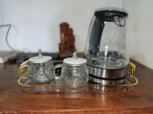 a tray with two cups and a tea kettle at Tiko Community Centre in Saint Francis