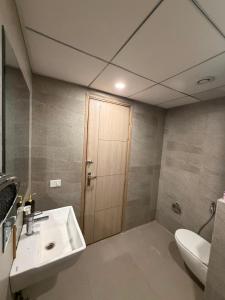 a bathroom with a sink and a toilet and a door at Max Stays in Greater Noida