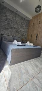 a large bed in a room with a stone wall at Alma-Librehouse in Kefalos