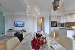 a dining room and kitchen with a table with flowers on it at Ohlerich Speicher App_ 03 in Wismar