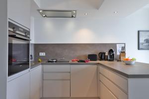 a kitchen with white cabinets and stainless steel appliances at Ohlerich Speicher App_ 03 in Wismar +23 photos