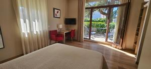 a bedroom with a bed and a window with a table and chairs at Le Castelet des Alpilles in Saint-Rémy-de-Provence +63 photos