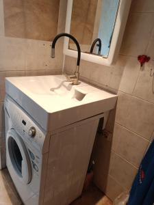 a washing machine under a sink in a bathroom at Jurmala-Sloka in Jūrmala