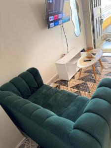 a green couch in a living room with a tv at Tulivu Homes in Meru