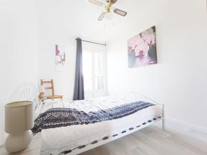 a white bedroom with a bed and a ceiling fan at APPARTEMENT à 5 mn de la plage in Saint-Hilaire-de-Riez