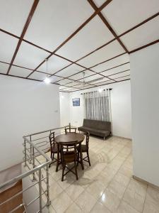 a room with a table and chairs and a couch at Lion Isle Residence in Anuradhapura