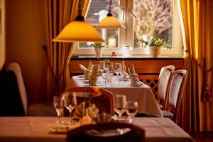 a dining room with a table with wine glasses at Püttmanns Dorfhotel in Olpe