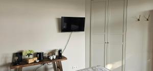 a living room with a tv on a wall at B&B La Rivé in Maastricht