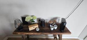a wooden table with coffee makers and flowers on it at B&B La Rivé in Maastricht