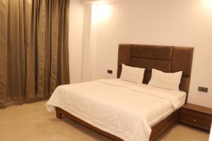 a bedroom with a large bed with white sheets at Hotel centrum in Roorkee