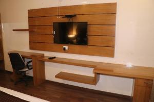 a room with a desk with a tv on a wall at Hotel centrum in Roorkee