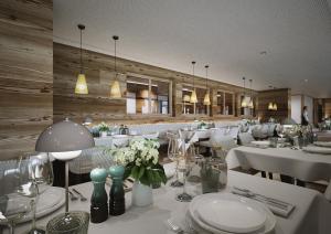 a restaurant with white tables and chairs and flowers at Gorfion Familienhotel in Malbun
