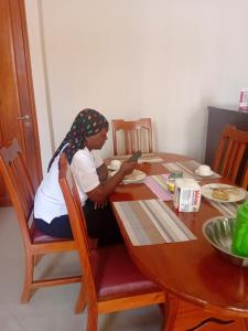 a woman sitting at a table with a cell phone at Ponte Vedra Lodge in Mwanza