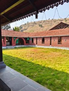 a large courtyard with a large field of grass at Ashoka Resort in Wai