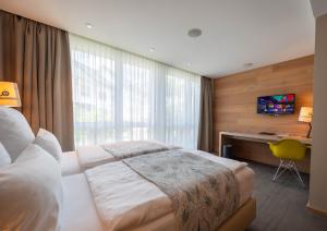 a bedroom with a bed with a desk and a window at Berliner Hof Bed&Bike in Saint-Vith