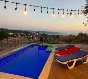 a swimming pool with chairs and lights on a roof at Rickystone in Jiwār al Bawāshiq +9 photos