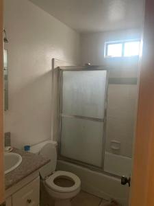a white bathroom with a toilet and a sink at Palm Cabin in San Gabriel