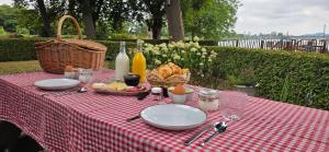 a picnic table with plates of food and a basket of bread at B&B La Rivé in Maastricht +6 photos