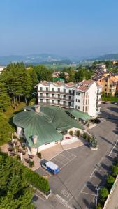 a building with a green roof and a parking lot at Pineta Bike Hotel in Cerro Veronese