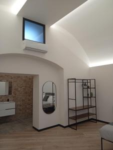ein Wohnzimmer mit einem Spiegel und einem Fernseher an der Decke in der Unterkunft Borgo Double V in Neapel